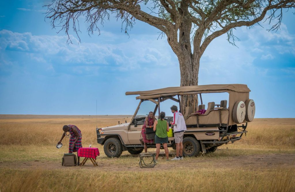 Guests enjoying a luxury bush breakfast during an African safari in Maasai Mara National Reserve, Kenya – exclusive safari experience with stunning savanna views, wildlife adventures, and personalized Kenya Tanzania safari tours by Cotis Safaris